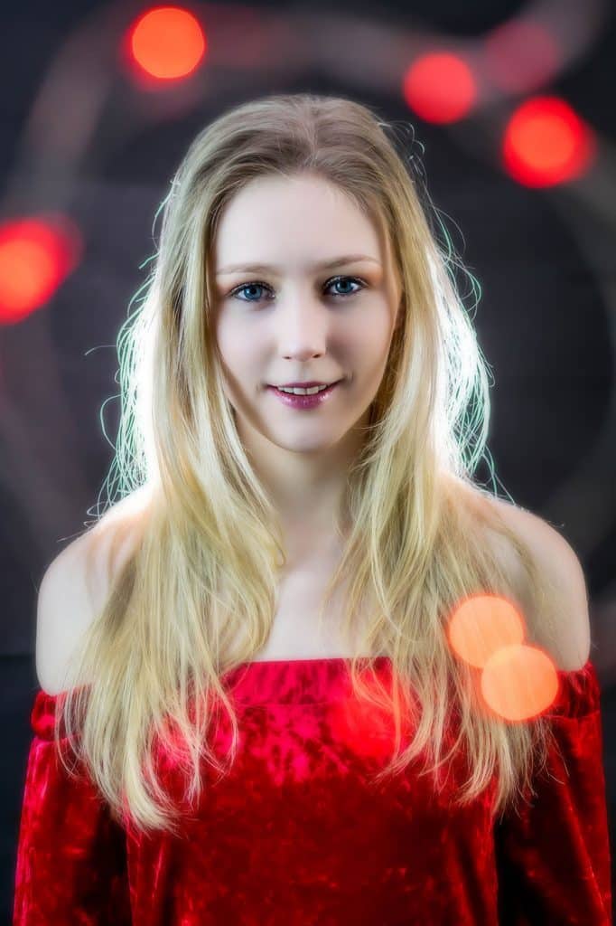 Studio portrait shoot, black background, soft focus effect in red dress with red lights